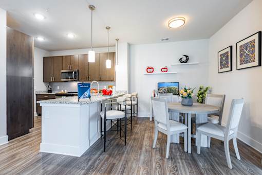 A modern kitchen with a dining table set for four.