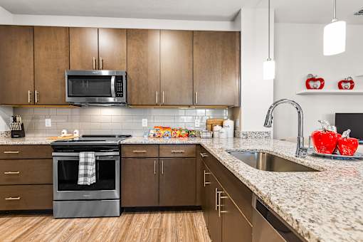 A kitchen with wooden cabinets and a black oven.