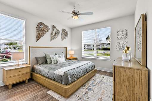 A bedroom with a bed, nightstand, and a fan.