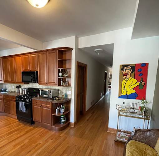 A kitchen with wooden cabinets and a painting on the wall.