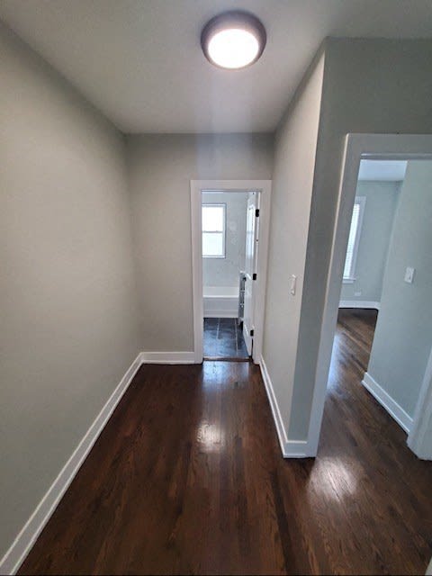 a empty room with a wooden floor and a door to a bathroom