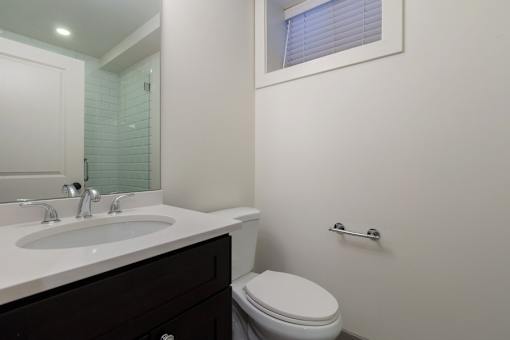 A white toilet sits next to a sink in a bathroom.
