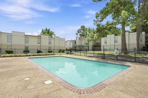 A small pool in a courtyard surrounded by buildings.