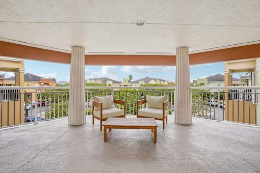 A balcony with a chair and a table.