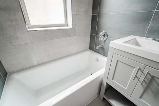 A white bathroom with a tub and sink.