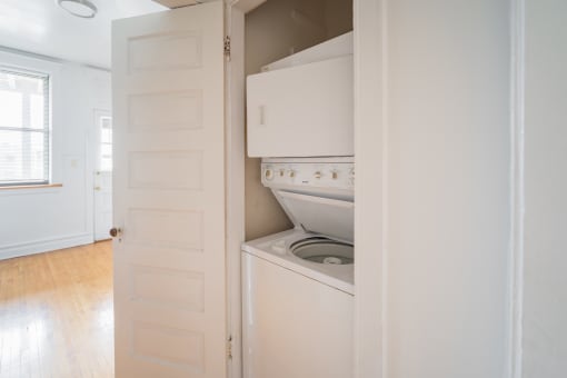 a small kitchen with a white stove and refrigerator and a white door