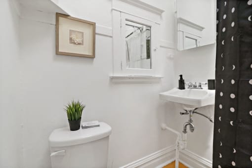 a white bathroom with a toilet and a sink
