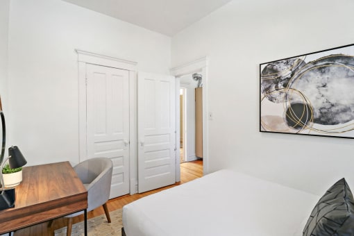 a bedroom with a bed and a desk and a closet