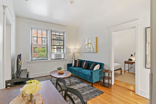 a living room with a blue couch and a dining room table