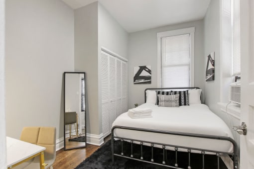 a small bedroom with a bed and a mirror
