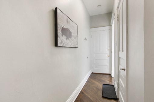 a hallway of a home with white walls and a white door