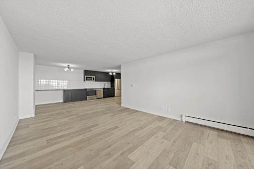 A room with wooden flooring and white walls.