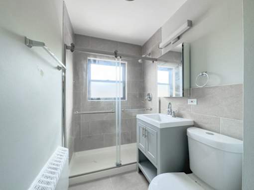 a white bathroom with a shower and a sink and a toilet