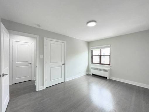 an empty living room with two doors and a window