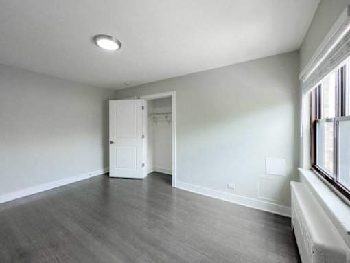an empty living room with white walls and wood floors