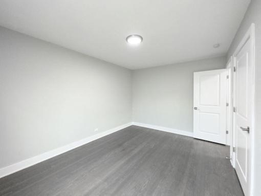 an empty living room with white walls and wood floors