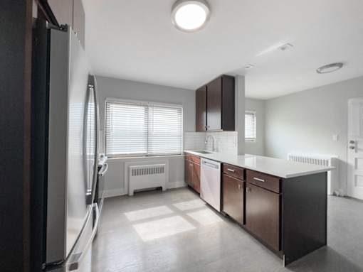 an empty kitchen with a refrigerator and a sink