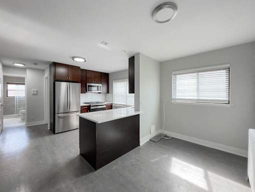 an empty kitchen with stainless steel appliances and a large window