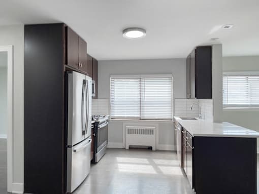 an empty kitchen with white appliances and black cabinets