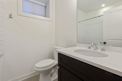 A white toilet sits next to a white sink in a bathroom.