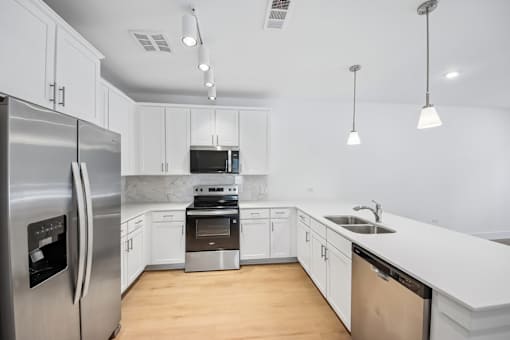 A modern kitchen with a stainless steel refrigerator and a dishwasher.