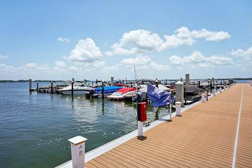 A dock with boats and a blue sky with clouds.