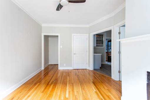 A room with a wooden floor and a ceiling fan.
