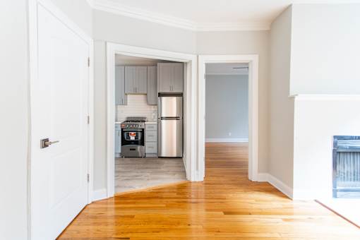 A kitchen with a white door and a white wall.