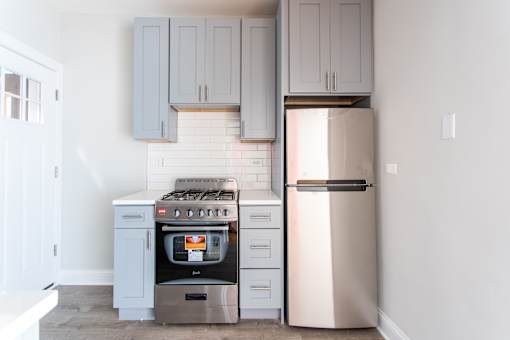 A kitchen with a stove and a refrigerator.