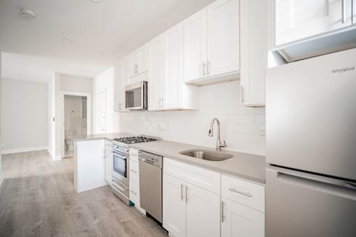 A kitchen with white cabinets and appliances.