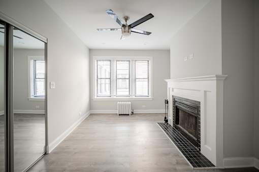 A room with a fireplace and a ceiling fan.