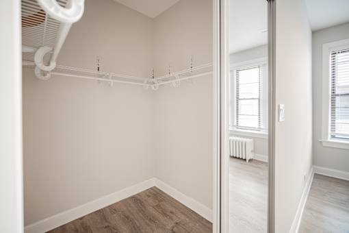 A white closet with a white shelf and a white fan.