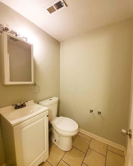 A white toilet and sink in a small bathroom.