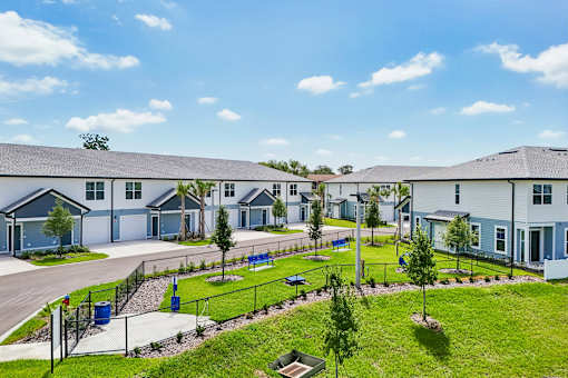 A row of houses with a green lawn in front.