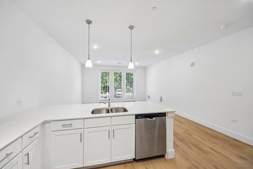 A kitchen with white cabinets and a stainless steel dishwasher.