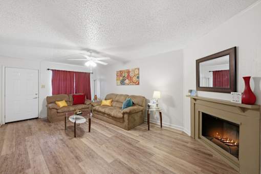 A living room with a fireplace and a painting on the wall.