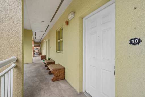 A hallway with a white door and a number 10 on the wall.