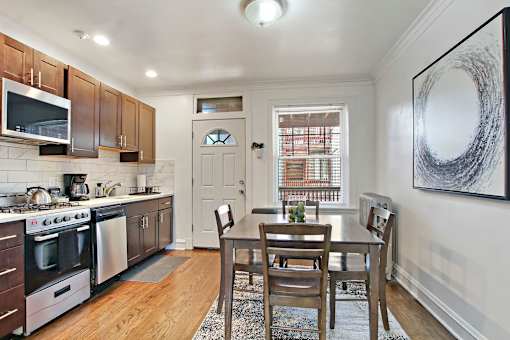 A kitchen with a dining table and chairs.