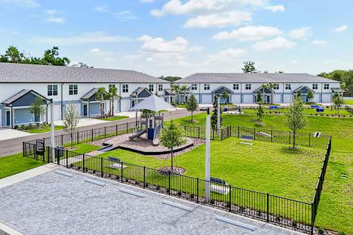 A large white building with a playground in front.