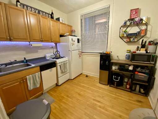 A small kitchen with wooden cabinets and a white refrigerator.