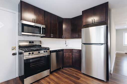 a kitchen with stainless steel appliances and dark wood cabinets