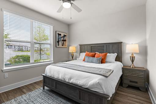 A bedroom with a large bed and a ceiling fan.