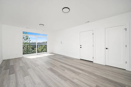 A room with a sliding glass door leading to a balcony.