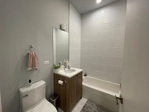A bathroom with a toilet, sink, and bathtub.