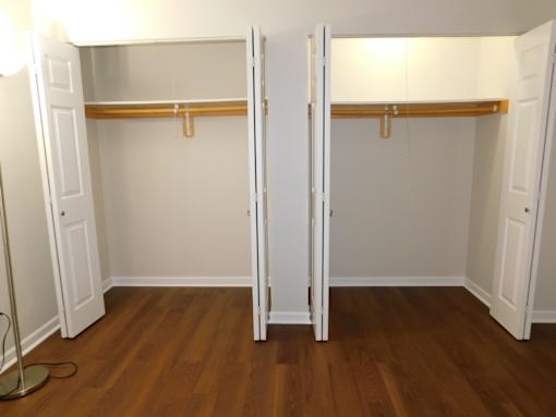 A room with two closets and a wooden floor.