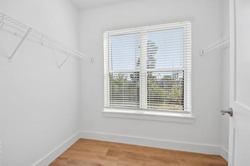A room with a window and a wooden floor.