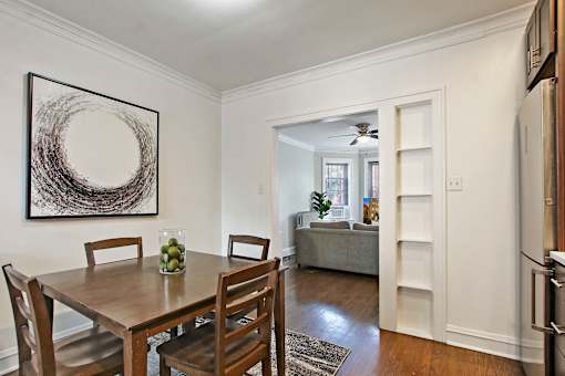 A dining room with a wooden table and chairs.