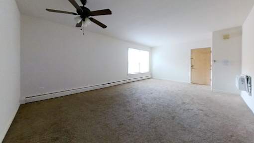 A room with a ceiling fan and carpeted floor.