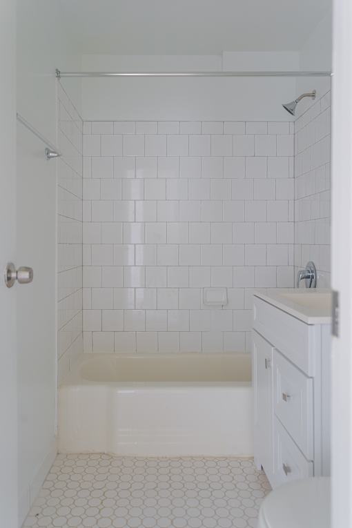 A white bathroom with a toilet, sink, and bathtub.