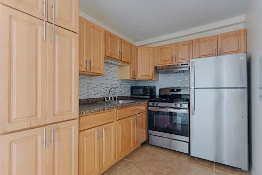 A kitchen with wooden cabinets and a white refrigerator.